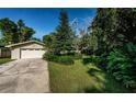 A well-maintained home featuring a two-car garage, lush landscaping, and a neatly manicured front lawn at 209 S Greenfield Ave, Temple Terrace, FL 33617