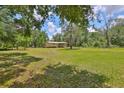 View of the exterior of the house with a spacious grassy yard surrounded by trees at 2112 33Rd Se St, Ruskin, FL 33570