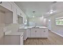 Modern kitchen featuring white cabinets, an island with a sink, and new flooring at 2112 33Rd Se St, Ruskin, FL 33570