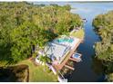 Aerial view of a home with pool, dock, boat, and waterfront access on canal at 2533 Dolly Bay Dr # 203, Palm Harbor, FL 34684