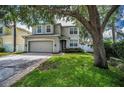 Exterior shot of a well maintained two story home with a neutral color scheme, two car garage and trimmed windows at 3002 Savannah Oaks Cir, Tarpon Springs, FL 34688