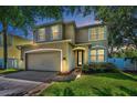 Exterior shot of a well maintained two story home with a neutral color scheme, two car garage and trimmed windows at 3002 Savannah Oaks Cir, Tarpon Springs, FL 34688