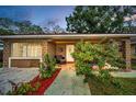 Charming single-story brick home featuring a cozy front porch with stylish outdoor seating and lush landscaping at 314 Bath St, Tarpon Springs, FL 34689