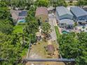 Aerial view of property showcasing backyard, tiki hut, shed, mature trees, and proximity to neighborhood pools at 316 Lafayette Blvd, Oldsmar, FL 34677