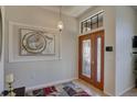 Inviting foyer showcasing a decorative glass front door, modern light fixture and artwork at 3338 Laurelwood Ct, Tarpon Springs, FL 34688