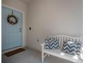 Up-close view of the inviting front door, featuring a wreath and a cozy bench with pillows at 3906 N Lynn Ave, Tampa, FL 33603