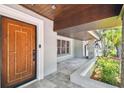 Inviting front porch featuring a decorative front door, tiled floor, and manicured landscaping at 405 S Shore Crest Dr, Tampa, FL 33609