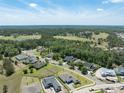 Expansive aerial view showcasing the community, lush green landscape, and a serene lake in the distance at 4056 Southern Valley Loop, Brooksville, FL 34601