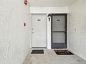 Exterior of condo entrance with welcome mat, doors, and fire safety system at 413 Meadow Ln # 81, Oldsmar, FL 34677