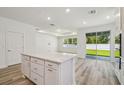 Spacious kitchen with island open to adjacent living area and sliding glass door to the back yard at 4303 Big Sky Dr, Spring Hill, FL 34604