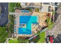 Birds eye view of two interlocked pools, blue lounge furniture, shaded umbrellas and green shrubbery at 6020 S Shore Blvd # 709, Gulfport, FL 33707