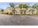 Inviting yellow condo complex with vibrant landscaping, palm trees, and private garages in a desirable neighborhood at 6319 Sunset Bay Cir, Apollo Beach, FL 33572
