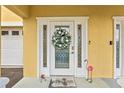 Inviting entryway features a decorative wreath, glass accents, and a charming flamingo, adding a touch of personality at 6319 Sunset Bay Cir, Apollo Beach, FL 33572