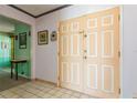A view of the home's light-filled foyer featuring a double-door entrance, tile flooring, and adjacent dining room at 7317 W Pocahontas Ave, Tampa, FL 33634