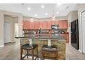 Modern kitchen featuring a central island with bar seating, stainless steel appliances, and stone backsplash at 7518 Tangle Brook Blvd, Gibsonton, FL 33534