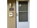 Close up of the townhome front door with address, light fixture, and mailbox at 7605 W Deleon Ct, Tampa, FL 33615