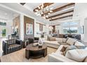 Stunning living room with stone accent walls, wood beams, and an open-concept kitchen and dining area at 8913 Bernini Pl, Sarasota, FL 34240