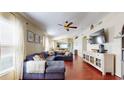 Spacious living room features hardwood floors, a ceiling fan, and a comfortable blue sectional sofa at 10739 Shady Preserve Dr, Riverview, FL 33579