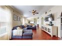 Bright living room featuring hardwood floors, a plush couch, and lots of natural light at 10739 Shady Preserve Dr, Riverview, FL 33579