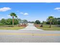 Inviting driveway entrance with brick columns and lush landscaping leading to a beautiful home at 11137 Woodland Waters Blvd, Weeki Wachee, FL 34613