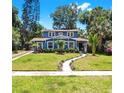 Beautifully landscaped front yard leading to a charming blue two-story home at 112 W Mohawk Ave, Tampa, FL 33604