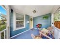 Inviting front porch with seating, decorative plants, and a cheerful yellow door at 112 W Mohawk Ave, Tampa, FL 33604