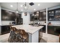 Gourmet kitchen featuring a large center island, granite countertops, and dark cabinetry with stainless appliances at 11550 Lake Lucaya Dr, Riverview, FL 33579