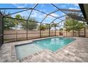 A private in-ground pool is enclosed in a black metal screened enclosure with a patio at 11550 Lake Lucaya Dr, Riverview, FL 33579