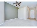 Spacious living room featuring plush carpeting, neutral walls, modern fan, and ample natural light at 11567 Weston Course Loop, Riverview, FL 33579