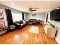 Cozy living room featuring hardwood floors, a ceiling fan, and a comfortable leather sofa set at 1233 Belleair Rd, Clearwater, FL 33756