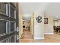 Welcoming foyer with hardwood floors, stylish rug, and views into the living spaces at 1666 Pine Pl, Clearwater, FL 33755