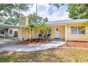 Charming yellow home featuring a welcoming front yard, and covered carport at 1713 W Louisiana Ave, Tampa, FL 33603