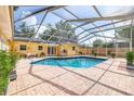 Inviting screened-in pool area with brick pavers and a covered patio, perfect for outdoor relaxation at 1713 W Louisiana Ave, Tampa, FL 33603