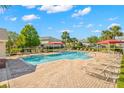 Community pool with lounge chairs and shade covers offering a relaxing outdoor space at 1749 Sedgefield Ct, Odessa, FL 33556