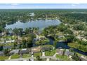 Beautiful aerial view of home surrounded by lush trees with water access to Lake Okahumpka at 18816 Tracer Dr, Lutz, FL 33549