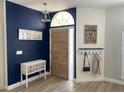 Inviting entryway with a wood door, stylish decor, and a blue accent wall at 19709 Wyndham Lakes Dr, Odessa, FL 33556