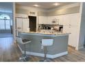 Eat-in kitchen with white cabinetry, granite countertops, and breakfast bar with seating at 19709 Wyndham Lakes Dr, Odessa, FL 33556