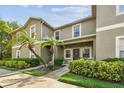 Exterior shot of a two-story condo featuring lush landscaping and a covered entryway with palm trees at 2347 Willimette Dr, Wesley Chapel, FL 33543
