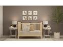 A cozy Bedroom featuring a wooden crib, neutral decor, and charming animal artwork at 2671 Buttercup Lucine Ln, Ruskin, FL 33570