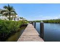 Wooden dock extending into tranquil water with lush greenery on the shoreline at 3125 Christophers Watch Ln, Ruskin, FL 33570
