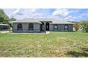 Single-story home with a well-maintained lawn and an attractive facade on a clear day at 31645 Bugle Ln, Wesley Chapel, FL 33543