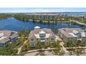 Aerial view of the yellow townhome, nestled beside a serene lake at 340 Sapphire Lake Dr # 202, Bradenton, FL 34209