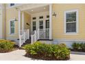 Inviting front porch with seating area and manicured landscaping enhances this yellow townhome at 340 Sapphire Lake Dr # 202, Bradenton, FL 34209