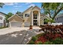Stately two-story home featuring a large double door entry, three car garage, and manicured landscaping in daylight at 4515 W Leona St, Tampa, FL 33629