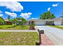 Well-manicured front lawn and landscaped garden of a single-story home with a two-car garage at 6705 Ranger Dr, Tampa, FL 33615