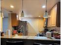 Well-lit kitchen with bar seating, stainless steel appliances, and ample countertop space at 8105 Sheldon Shores Dr, Tampa, FL 33615