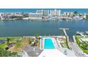 Community aerial view of sparkling pool and playground with bay views and waterway access at 10216 Regal Dr # 310, Largo, FL 33774