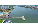 Aerial view featuring community waterfront access with a dock and pool with an expansive waterway view at 10216 Regal Dr # 310, Largo, FL 33774