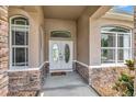 Welcoming front entrance with double doors framed by decorative stone and sidelight windows at 10305 Worthy Lamb Way, New Port Richey, FL 34654