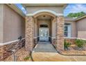 Inviting front entrance featuring stone accents, double doors, and manicured landscaping at 10305 Worthy Lamb Way, New Port Richey, FL 34654